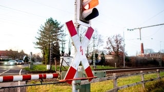 Symbolbild: Eine Ampel an einem Bahnübergang. In Tübingen sind zwei Menschen vor einfahrenden Zügen über die Gleise gelaufen.