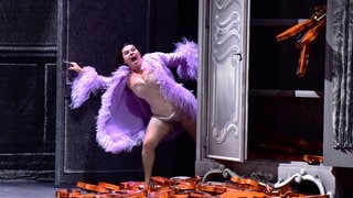 Sängerin Kathryn Lewek posiert in einem hautfarbenen Korsett und einem lila Morgenmantel im Rahmen der Aufführungen zu "Orpheus in der Unterwelt" bei den Salzburger Festspielen 2019