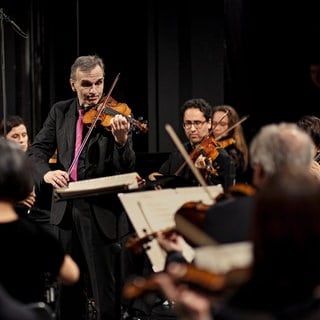 Nicholas McGegan (l.), Gil Shaham und das SWR Symphonieorchester
